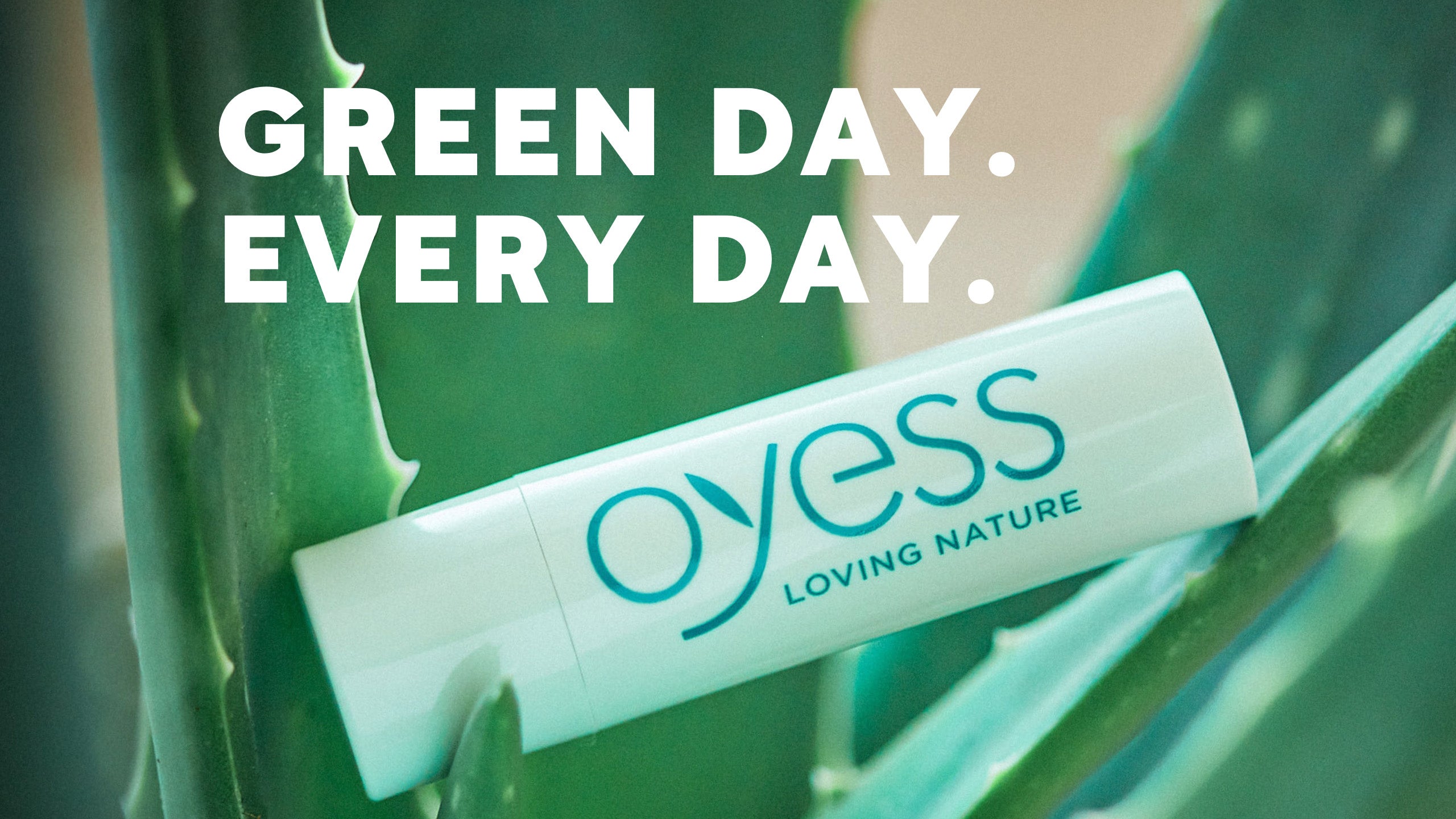 Ein OYESS Natural Lipbalm Stick zusammen mit Aloevera Blättern und dem Schriftzug Green Day. Every Day.